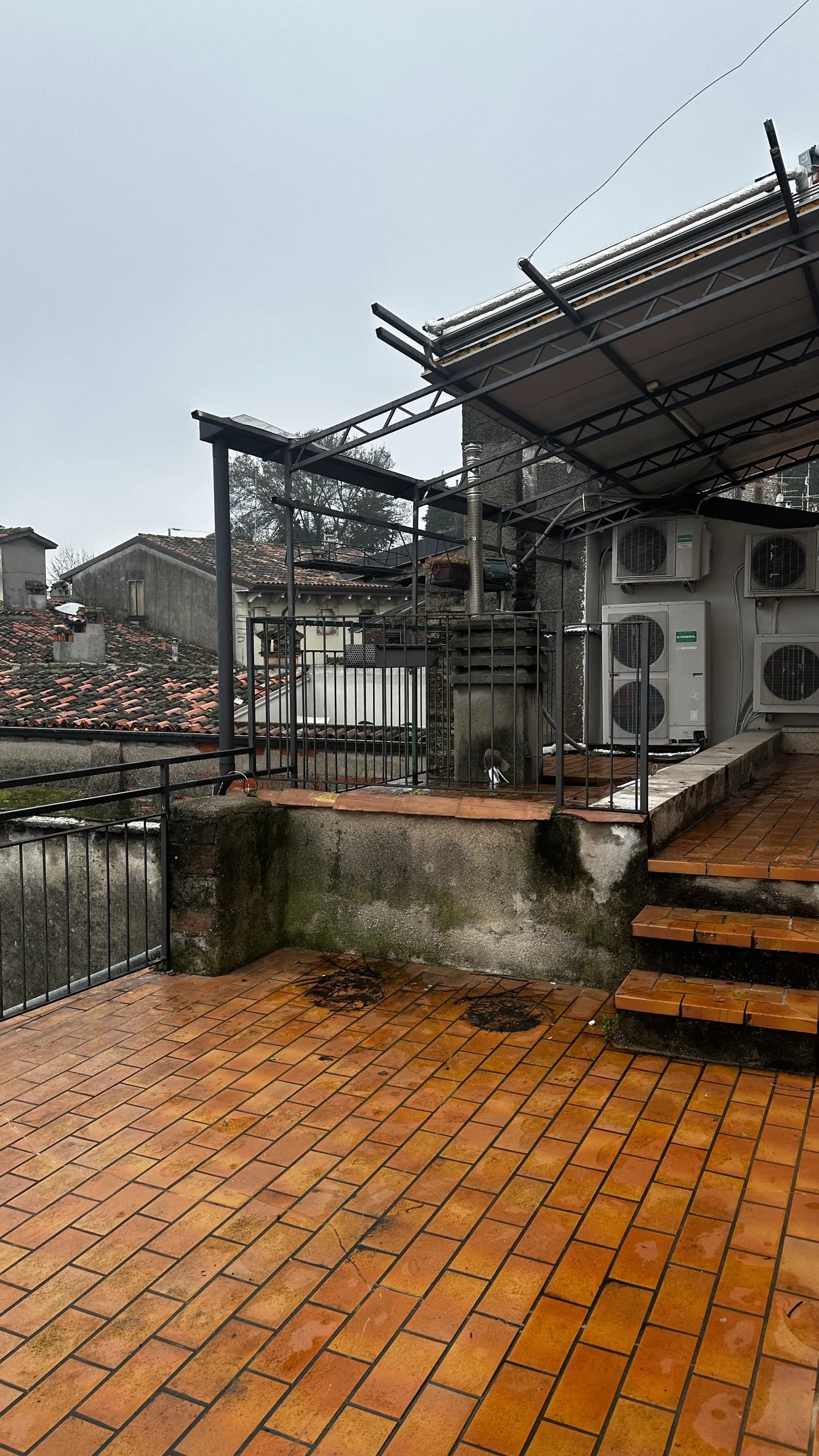 Terrazza in centro storico a Desenzano del Garda prima del recupero: pavimentazione in cotto consumata, struttura metallica arrugginita e spazio privo di identità