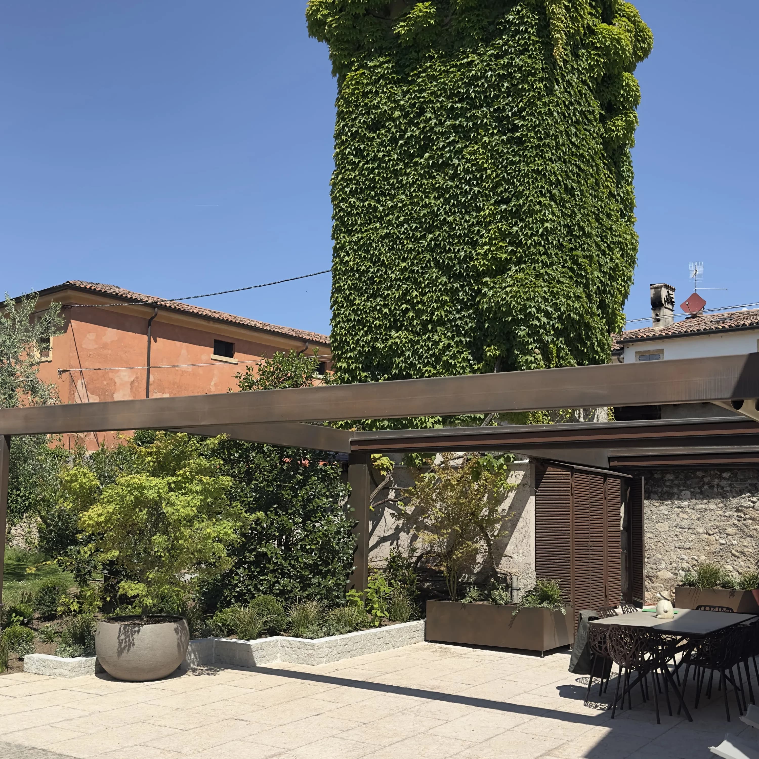 Portico ultimato con verde sempreverde e pergola corten a Illasi